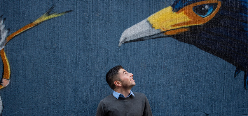 En mann ser ut på en tagg av en fugl. Foto.