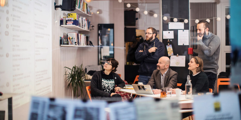 Five people looking at a projector screen. Photo.