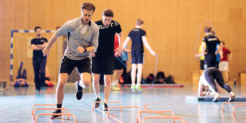 Two men running an obstacle course. Photo.