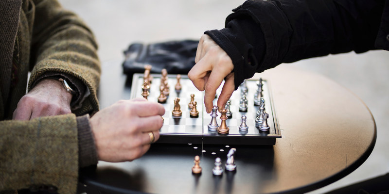 Two hand moving chess pieces. Photo. 