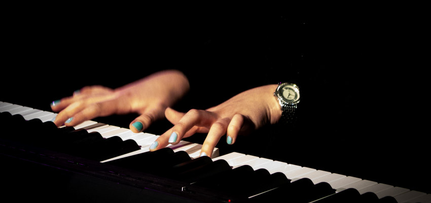 Hender som spiller på piano. Foto