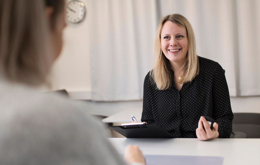 A smiling woman with a notepad. Photo. 