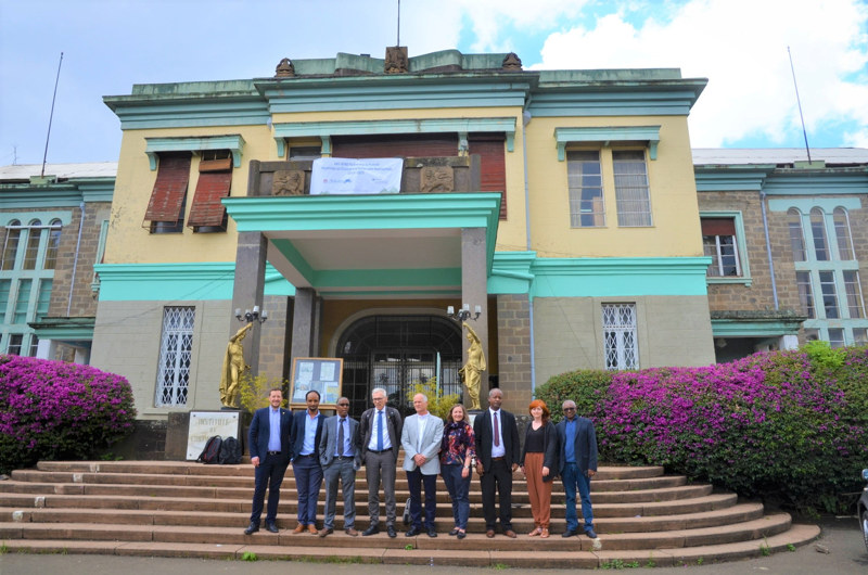 A group of people standing on the stairs in front of a building