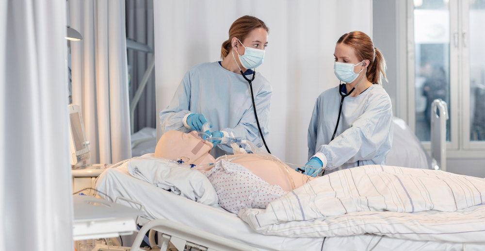 Sykepleiestudenter med pasientsimulator Bilde
