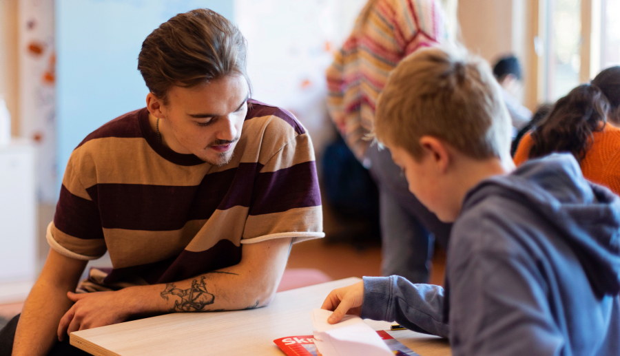 Male student and a boy. Notebook. Photo